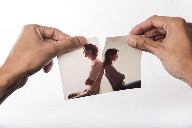 Dos manos partiendo por la mitad una fotografía de una pareja. Psicólogos Navalcarnero|||